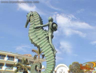 Foto Uma estátua de um cavalo-marinho na frente de um corpo de água –  Imagem de Puerto vallarta