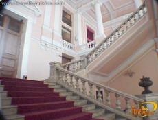 A white marble staircase leads to the main hall